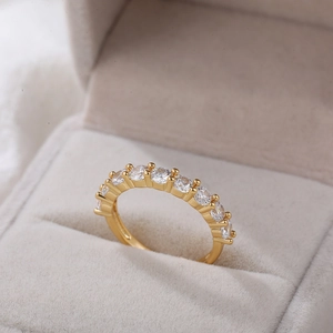 Macro-opname van vergulde ring met 11 ronde zirkonen in een beige fluwelen doosje