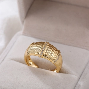 Detailweergave van verstelbare 18K gouden ring met verticale strepen en zirkoon