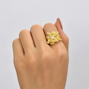 Macro detail van 18K gouden ring met geweven textuur, grote zirkoon en leeuwenkop accenten