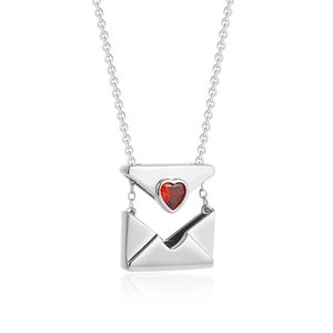 Macro shot of silver envelope locket pendant with red heart zircon and opening detail