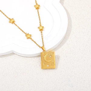 Detailed macro of 18K gold locket necklace with moon star patterns and star charms