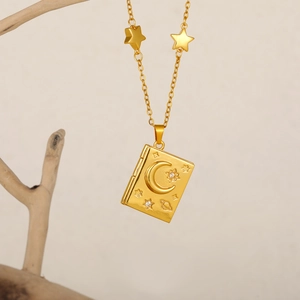 18K gold book locket necklace featuring celestial moon and star engravings and charms