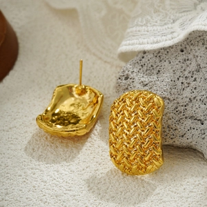 Detalle macro de pendientes en oro de 18K con textura trenzada y reverso de metal martillado
