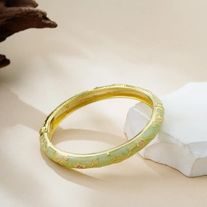 Detail of 14K gold enamel bracelet with light green floral pattern and hinge closure