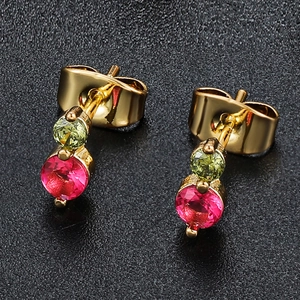 Detailed macro view of 18K gold earrings with green and pink round-cut cubic zirconia