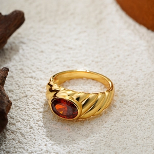 Detail of vintage 18K gold ring featuring a red oval zircon and croissant textured band