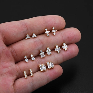 Macro shot of 18K gold plated earring set with white zircons held in a hand