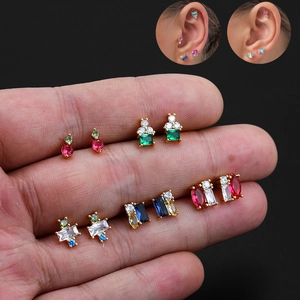 Detailed shot of 18K gold plated stud earrings with colorful cubic zirconia in hand