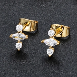 Detailed macro view of 18K gold earrings with vertical round and marquise-cut zircons