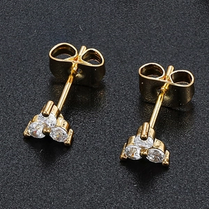 Macro detail of 18K gold cluster stud earrings with clear zircon stones on black background