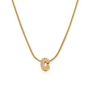 Macro view of 18K gold letter C pendant with pavé cubic zirconia on snake bone chain