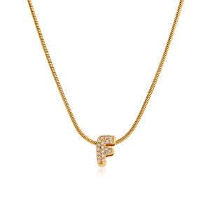 Detailed macro view of 18K gold letter F pendant with pavé set cubic zirconia on snake chain