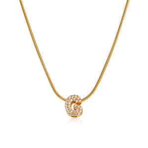 Detail of 18K gold letter G pendant with micro-paved zircons on a snake bone chain