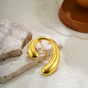 Detail view of gold spiral brooch with polished finish and secure back pin closure