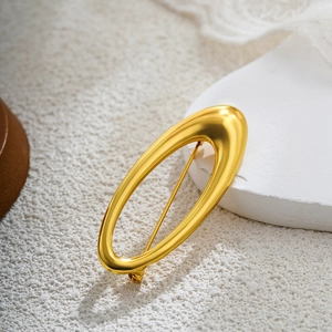 Detailed close-up of 18k gold-plated pearl spiral brooch with polished finish