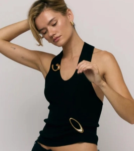Detail of black ribbed halter top featuring decorative gold metal rings and slim fit texture