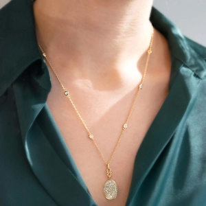 Gros plan du médaillon ovale plaqué or 18 carats avec cristaux de zircone micro-pavés
