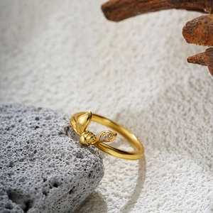 Elegant 18K gold knot bow ring with zircons on natural stone background for women