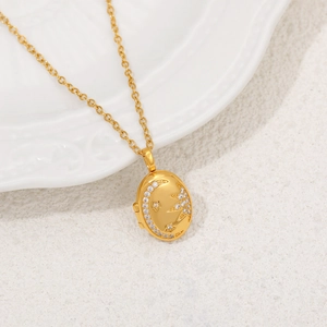 Détail d'un médaillon en or 18 carats avec motif étoile et lune et pierres en zircon