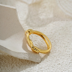Detail of 18K gold knotted ring featuring twisted rope design and sparkling pavé zircons