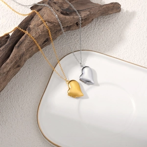 Vue détaillée des pendentifs médaillon cœur en or et argent sur un plateau en céramique