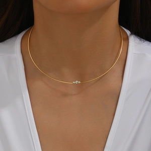 Gros plan du collier choker en acier doré 18K avec trois pierres de zircon brillantes