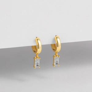 Detalle macro de pendientes de plata S925 bañados en oro de 14K con colgante de circón rectangular