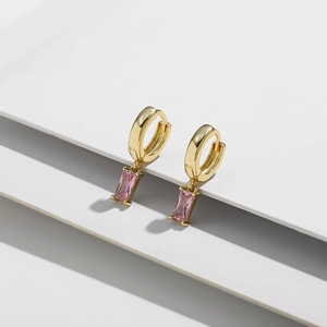 Detalle macro de pendientes de aro bañados en oro de 14K con circonitas rosas
