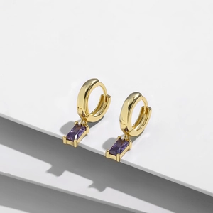 Vista macro de aretes de aro bañados en oro de 14K con colgantes de circón violeta rectangulares