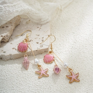 Détails rapprochés de boucles d'oreilles coquillage en or 14 carats et émail rose