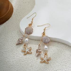 Détail des breloques étoile de mer et coquillage avec perle blanche sur crochet doré