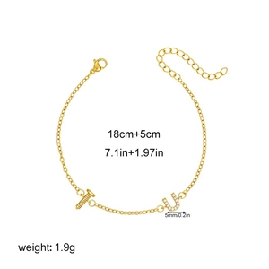 Detalle de pulsera de oro de 18K con letra U de circón y dije de tornillo en cadena delicada