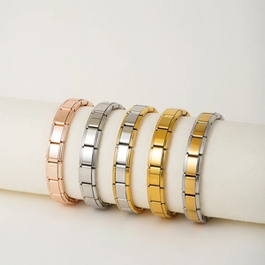 Five Italian modular charm bracelets in gold, silver, and rose gold finishes on props