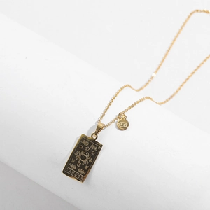 Detail view of gold Cancer zodiac tarot square pendant and constellation round charm necklace
