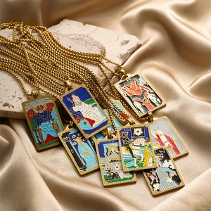 Golden tarot pendant necklaces with colorful enamel motifs on elegant silk fabric