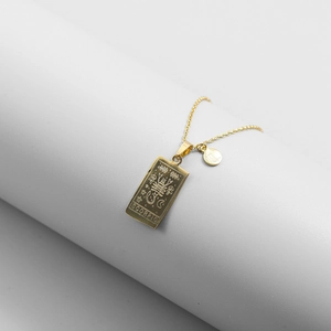 Detailed close-up of gold Scorpio square pendant necklace with zodiac engraving