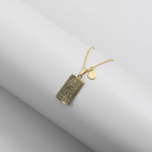 Detail of gold Virgo pendant necklace featuring a rectangular plate and zodiac sign charm