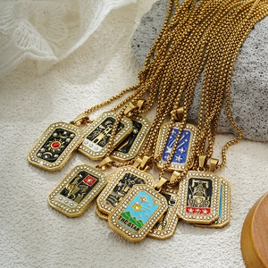 Macro view of gold tarot card pendants with inlaid rhinestones and box chain detailing