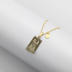 Detailed close-up of Taurus zodiac engraved gold square pendant and round symbol charm