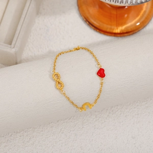 Detail of 18K gold-plated chain bracelet with red enamel heart and infinity symbol