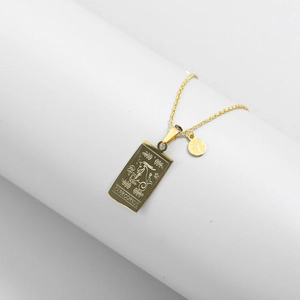 Detailed macro view of gold-plated Capricorn square pendant and Aries charm on thin chain