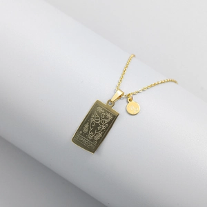 Macro detail of gold Capricorn tarot pendant and zodiac charm on a fine link chain