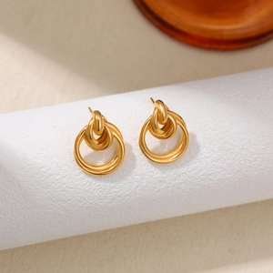 Detalle de pendientes de doble aro entrelazados en oro de 18 quilates en soporte