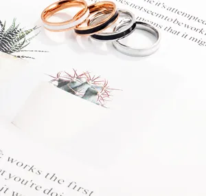 Macro-opname van minimalistische emaille ringen in roségoud en zilver op stijlvolle kaart