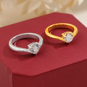 Detailed view of silver and gold V-shaped rings with sparkling cubic zirconia on a gift box