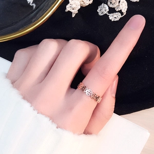 Ring mit ausgehöhltem Münzmuster in 18k Roségold-Finish, am Zeigefinger getragen