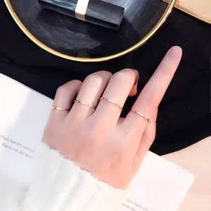 Minimalistisches Set aus roségoldenen Edelstahlringen an der Hand mit weißem Pullover