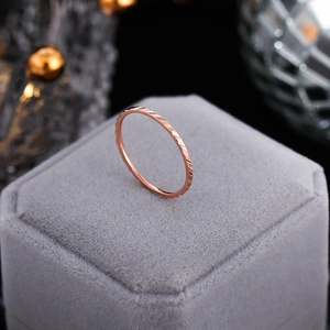 Detail of rose gold faceted ring with light-reflecting textures on a jewelry box