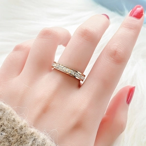 Detail eines roségoldenen Eternity-Rings mit quadratischen Kristallen auf Plüschgrund
