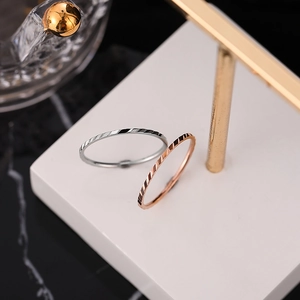 Minimalist stainless steel rings in silver and rose gold with textured geometric surfaces